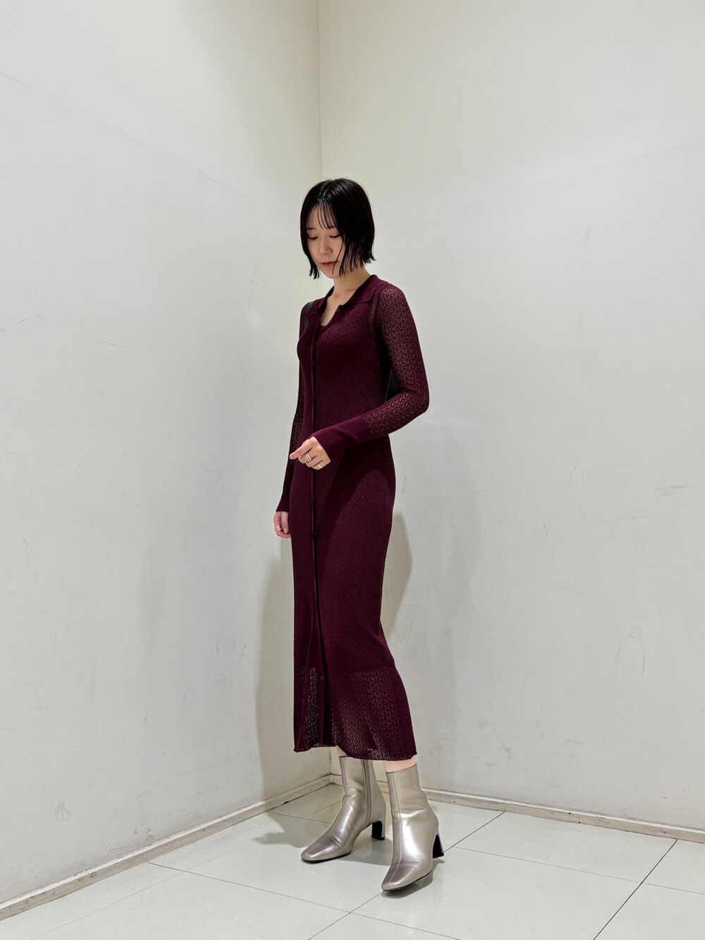 パープル系のワンピース、ブラック系のショルダーバッグ、シルバー系のブーツを着用したレディースの秋コーディネートの3枚目の写真