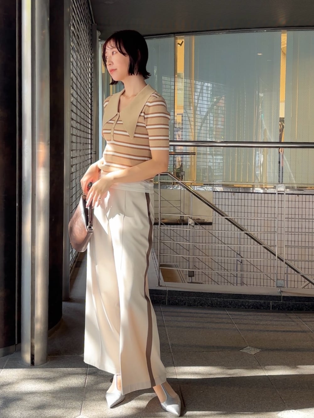 ホワイト系のその他パンツ、シルバー系のパンプス、ブラウン系のハンドバッグを着用したレディースの冬コーディネートの2枚目の写真