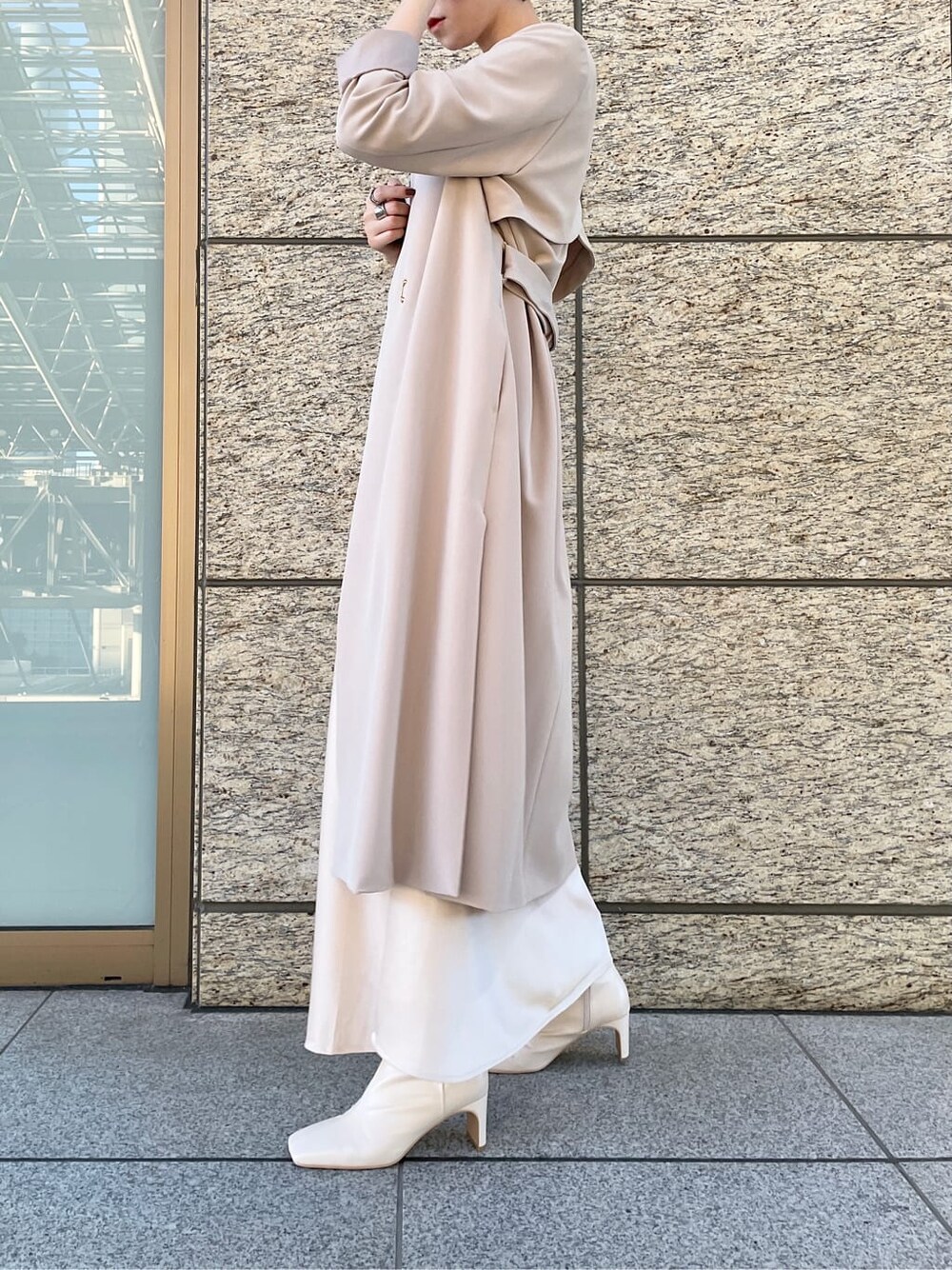 ホワイト系のスカート、ホワイト系のノーカラーコート、ブラック系のニット/セーターを着用したレディースの冬コーディネートの3枚目の写真