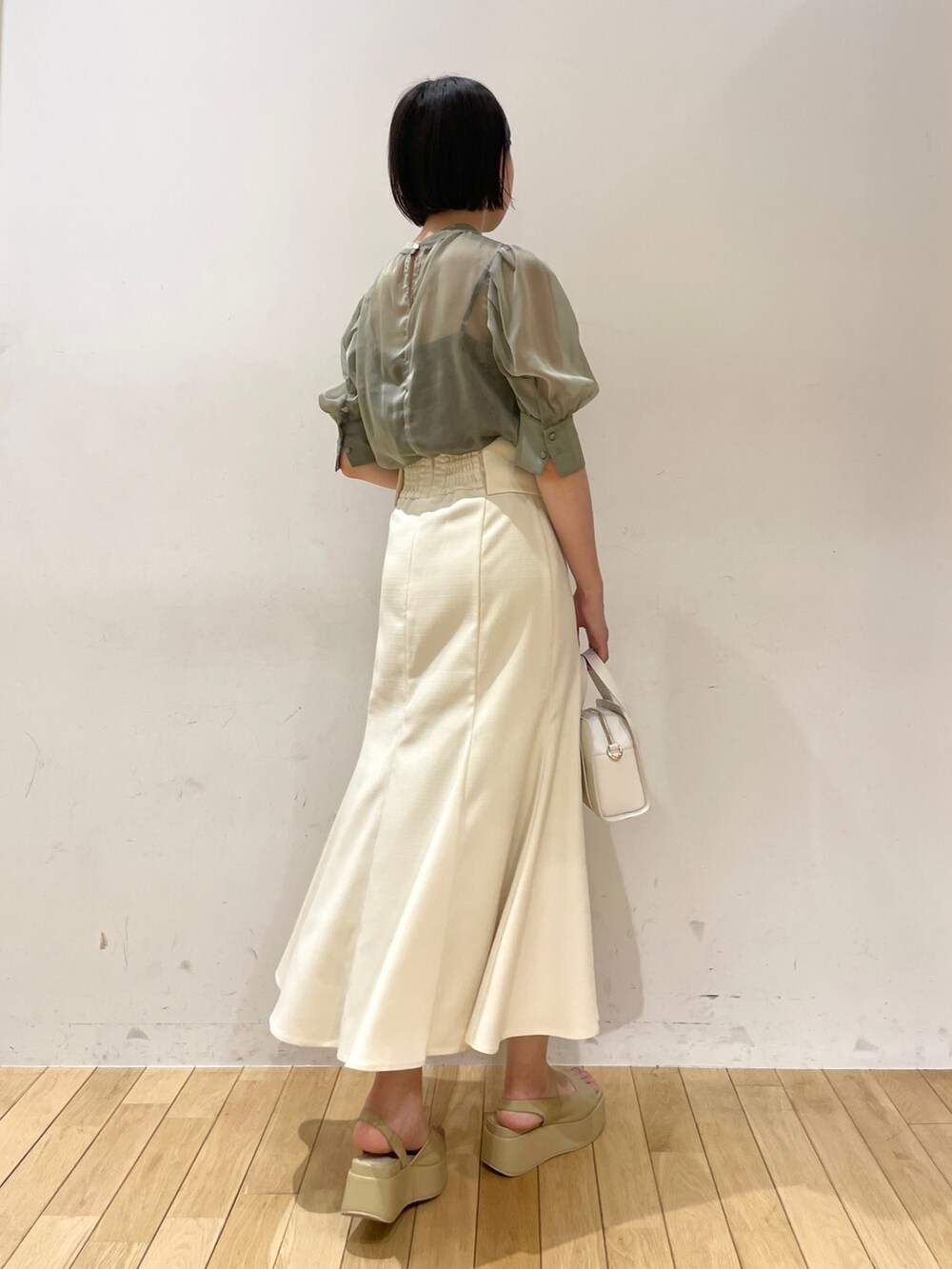 グリーン系のシャツ/ブラウス、ホワイト系のスカート、ホワイト系のショルダーバッグを着用したレディースの夏コーディネートの3枚目の写真