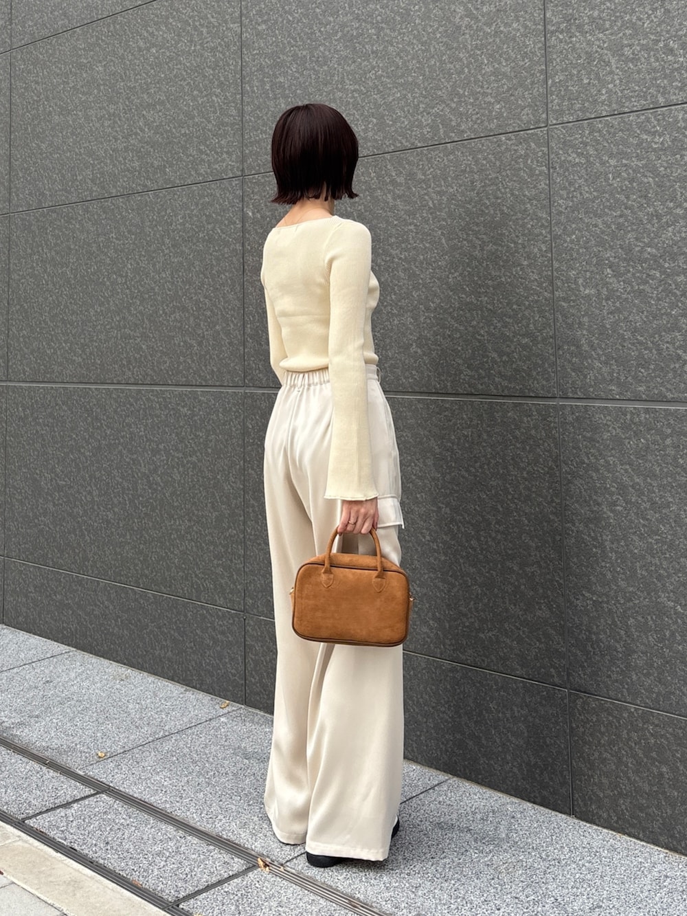 ホワイト系のカーゴパンツ、ホワイト系のニット/セーター、イエロー系のハンドバッグを着用したレディースの冬コーディネートの2枚目の写真