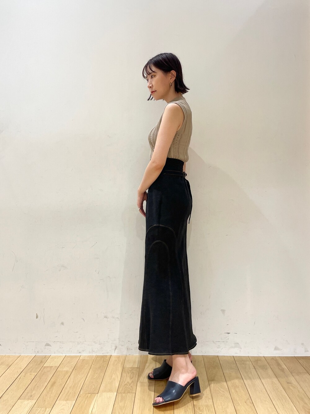 ベージュ系のニット/セーター、ブラック系のデニムスカート、ブルー系のサンダルを着用したレディースの夏コーディネートの4枚目の写真