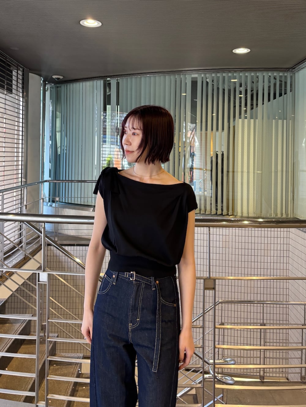 ブルー系のデニムパンツ、ブラック系のパンプス、ブラック系のニット/セーターを着用したレディースの春コーディネートの3枚目の写真