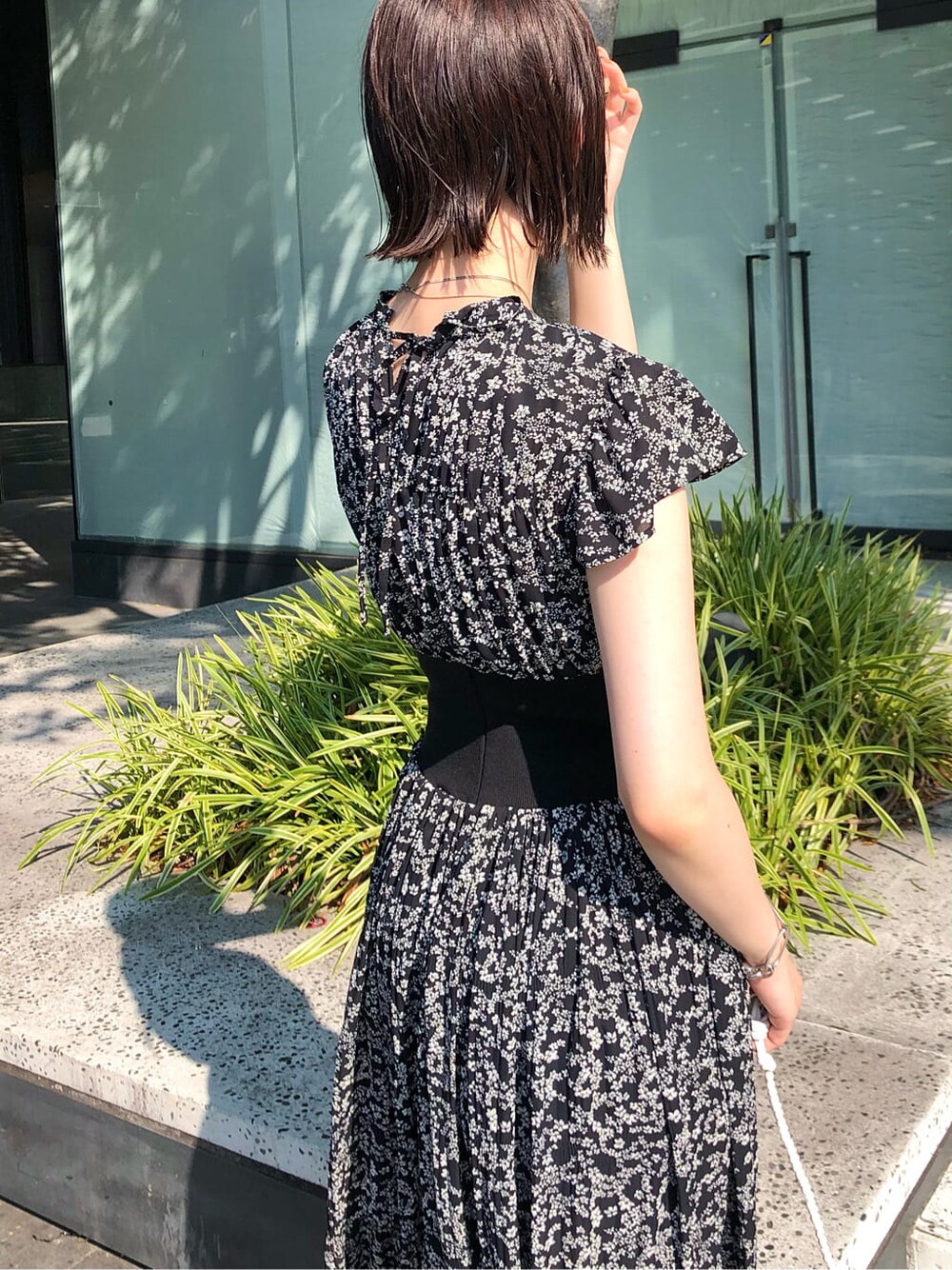 ホワイト系のショルダーバッグ、ブラック系のワンピース、ブラウン系のサンダルを着用したレディースの夏コーディネートの7枚目の写真