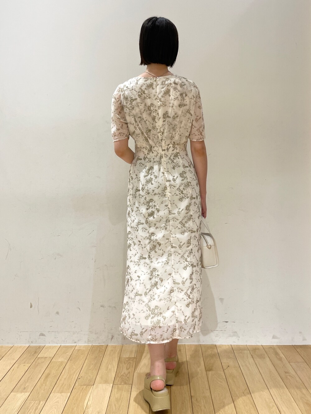 ホワイト系のワンピース、ホワイト系のショルダーバッグ、ベージュ系のサンダルを着用したレディースの夏コーディネートの4枚目の写真