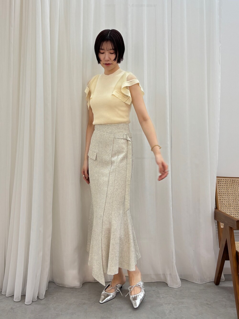 シルバー系のサンダル、ホワイト系のスカート、ホワイト系のニット/セーターを着用したレディースの春コーディネートの2枚目の写真