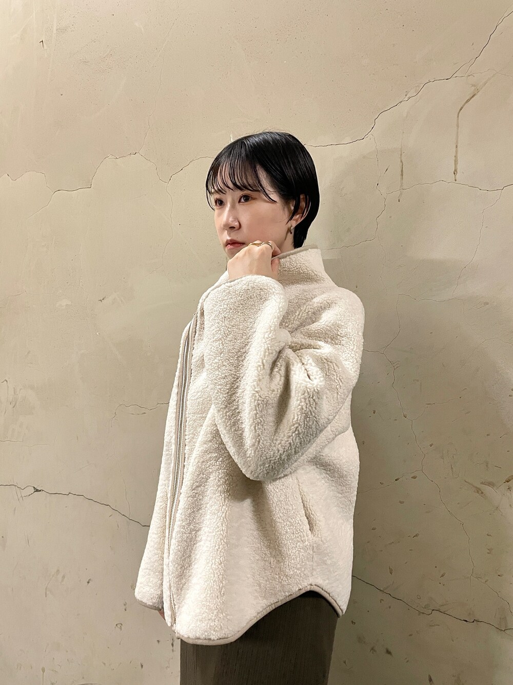 ホワイト系のブルゾン、ブラック系のブーツ、ブラウン系のワンピースを着用したレディースの秋コーディネートの5枚目の写真