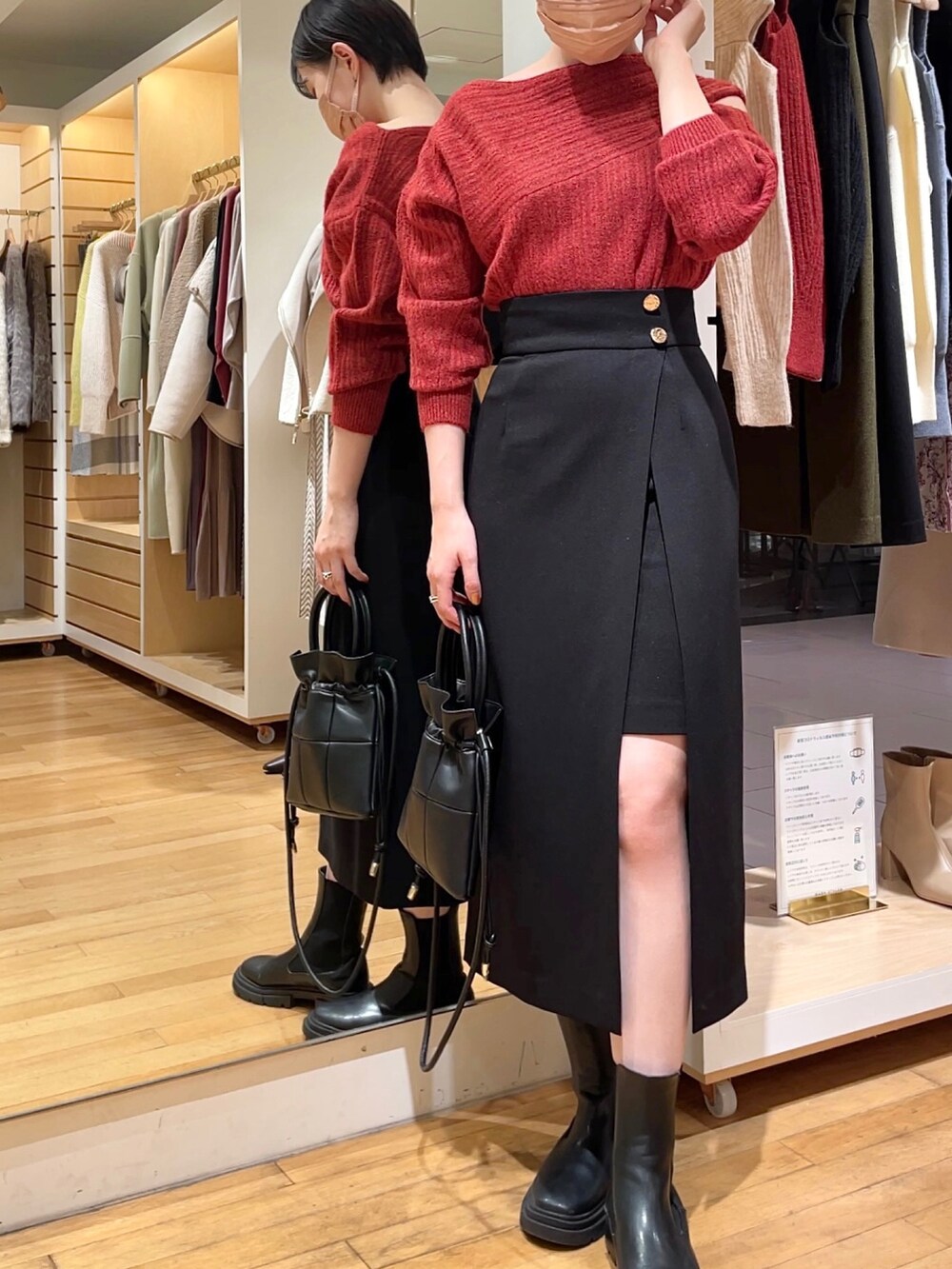 ブラック系のスカート、ブラック系のニット/セーター、ブラック系のハンドバッグを着用したレディースの冬コーディネートの2枚目の写真