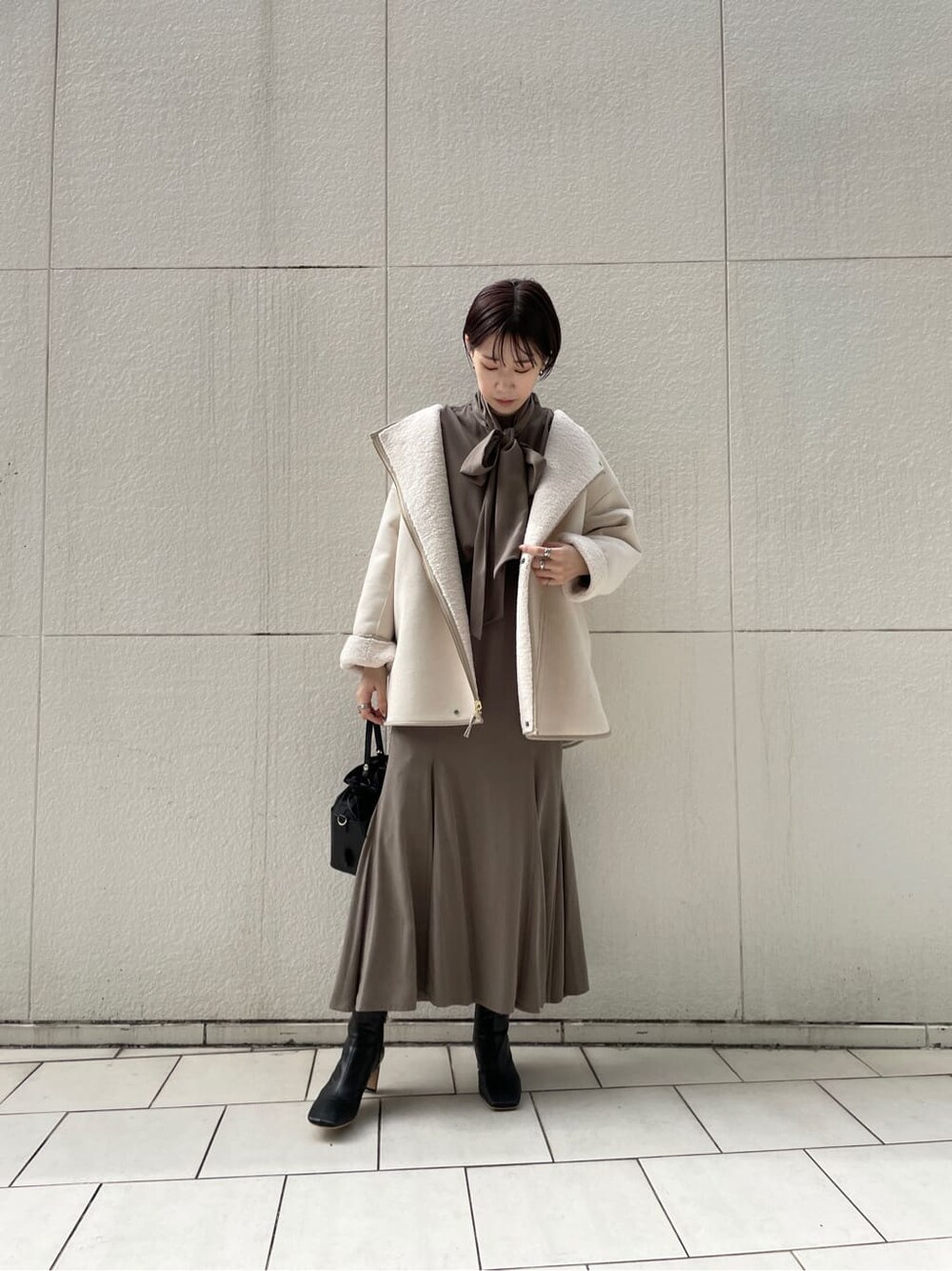 ブラック系のその他シューズ、ホワイト系のその他アウター、ブラウン系のシャツ/ブラウスを着用したレディースの冬コーディネートの7枚目の写真