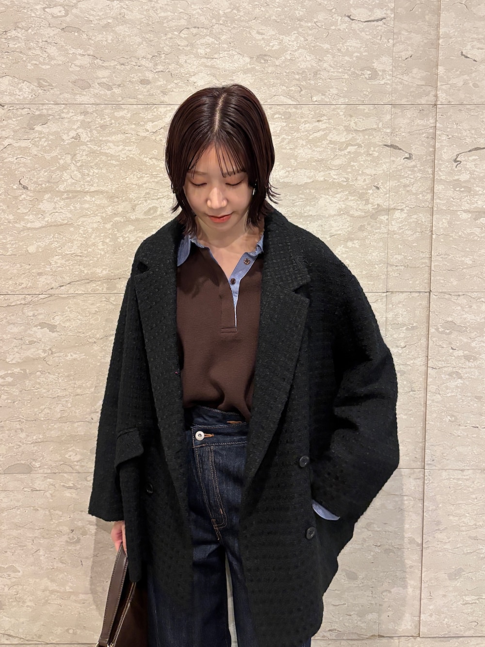 ブラウン系のニット/セーター、ブラック系のその他アウター、ブラウン系のブーツを着用したレディースの冬コーディネートの5枚目の写真