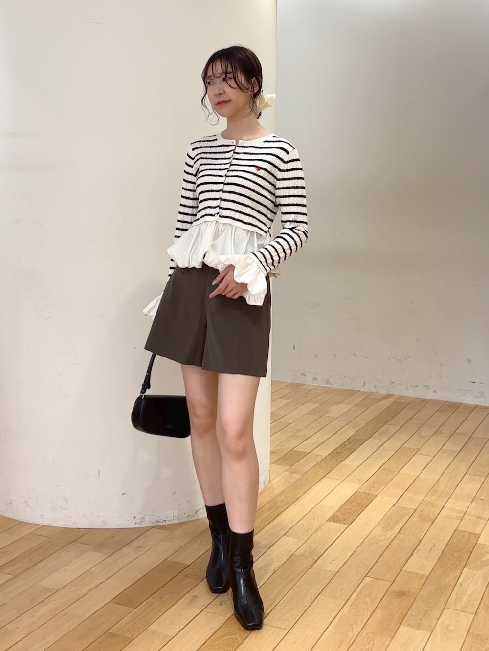 ブラウン系のその他パンツ、ブラック系のハンドバッグ、ブラック系のブーツを着用したレディースの夏コーディネートの2枚目の写真
