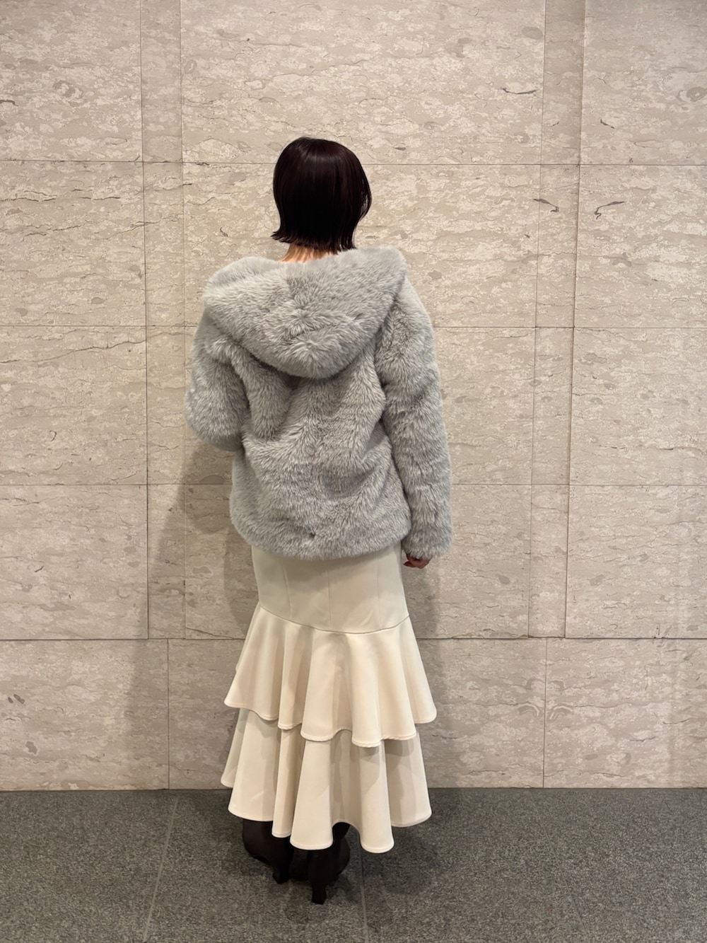 ピンク系のニット/セーター、ブラウン系のブーツ、ホワイト系のスカートを着用したレディースの冬コーディネートの4枚目の写真