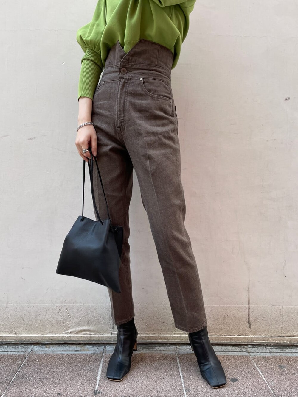 ブラック系のその他シューズ、ブラック系のハンドバッグ、グリーン系のニット/セーターを着用したレディースの冬コーディネートの2枚目の写真