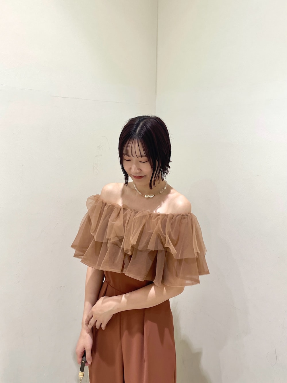 オレンジ系のパンツドレス、その他のクラッチバッグ、その他のパンプスを着用したレディースの夏コーディネートの5枚目の写真