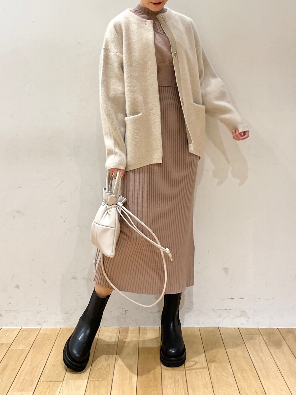 ホワイト系のカーディガン/ボレロ、ベージュ系のワンピース、ホワイト系のハンドバッグを着用したレディースの冬コーディネートの4枚目の写真