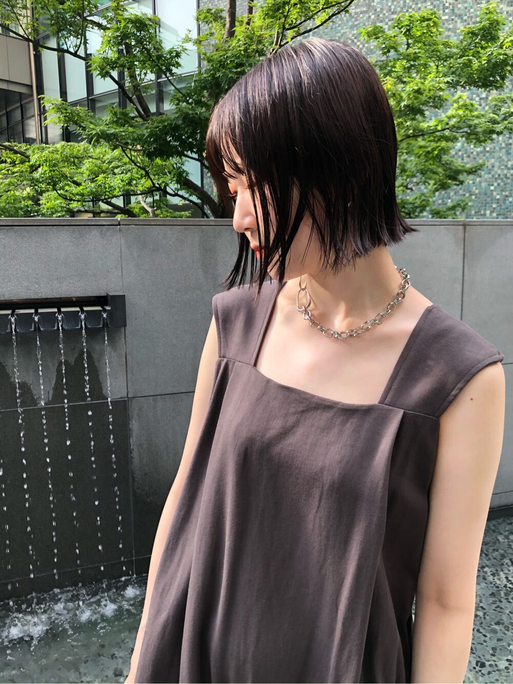 イエロー系のサンダル、グレー系のワンピース、シルバー系のネックレスを着用したレディースの夏コーディネートの3枚目の写真