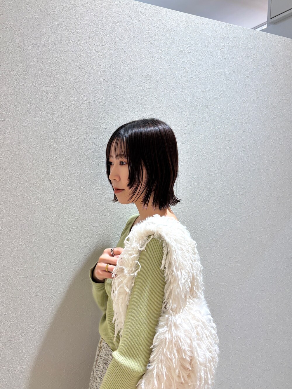 ホワイト系のその他パンツ、グリーン系のニット/セーター、ホワイト系のハンドバッグを着用したレディースの冬コーディネートの5枚目の写真