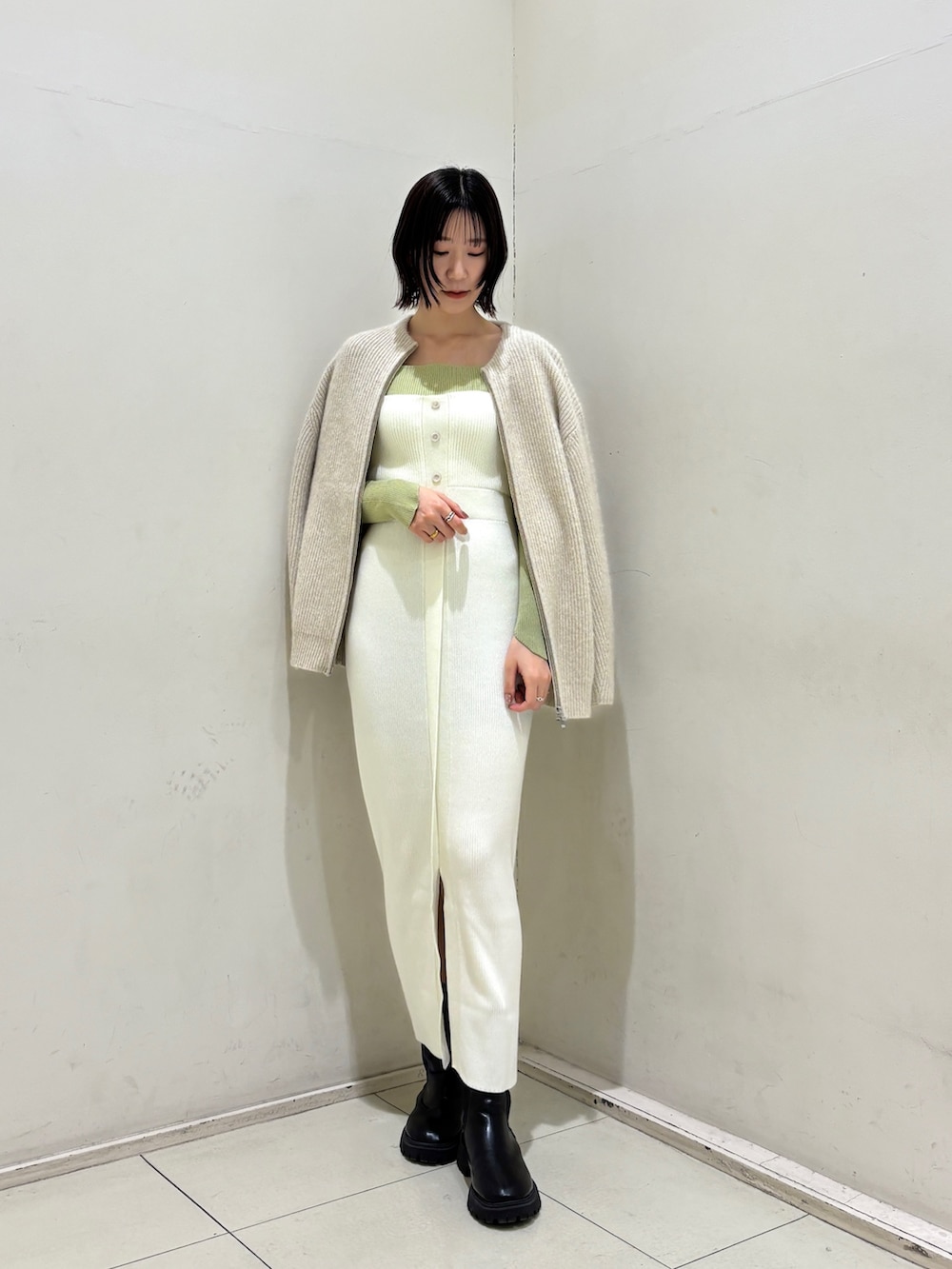 ホワイト系のワンピース、グリーン系のニット/セーター、ホワイト系のハンドバッグを着用したレディースの冬コーディネートの6枚目の写真