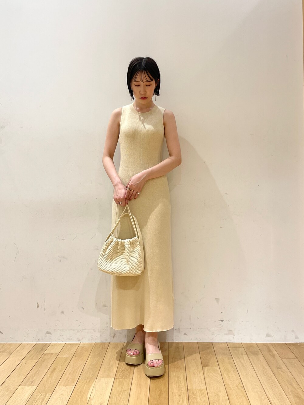 ベージュ系のワンピース、ブラウン系のハンドバッグ、ベージュ系のサンダルを着用したレディースの夏コーディネートの7枚目の写真