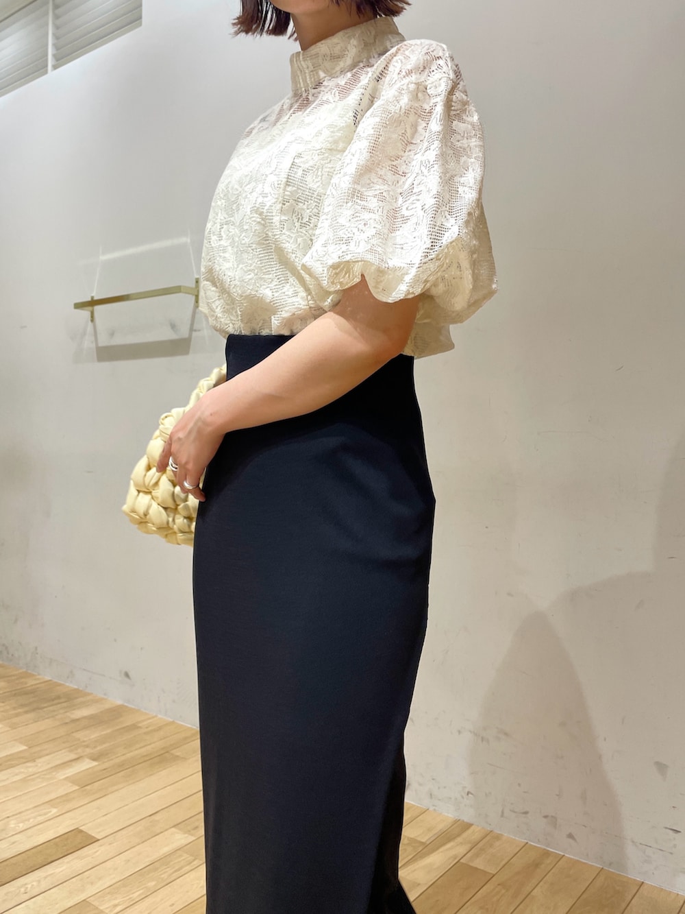 ベージュ系のハンドバッグ、ブラック系のサンダル、ホワイト系のシャツ/ブラウスを着用したレディースの夏コーディネートの7枚目の写真