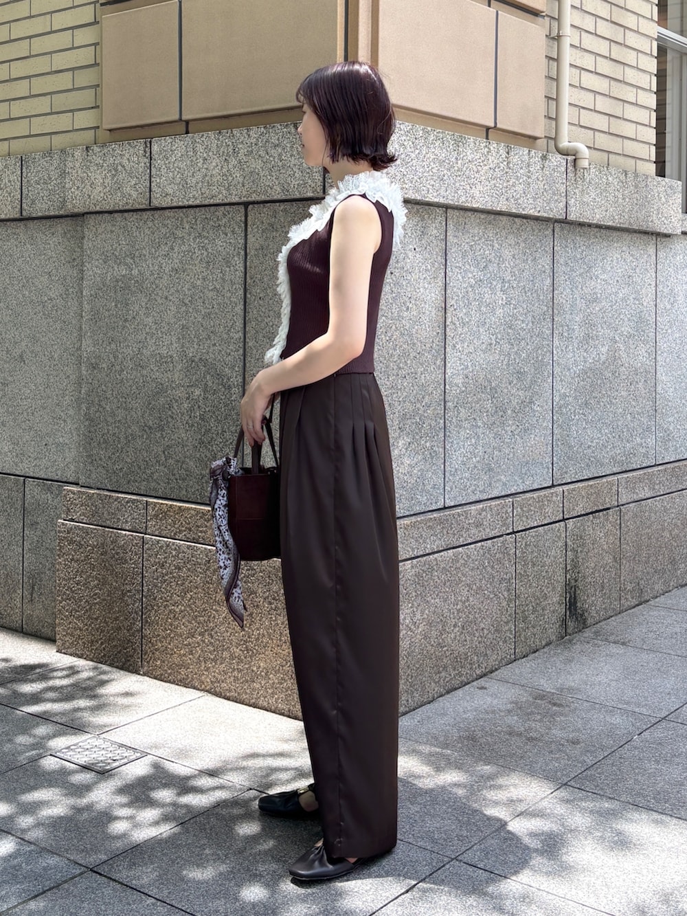 ブラウン系のその他パンツ、ブラウン系のハンドバッグ、ブラウン系のサンダルを着用したレディースの夏コーディネートの2枚目の写真