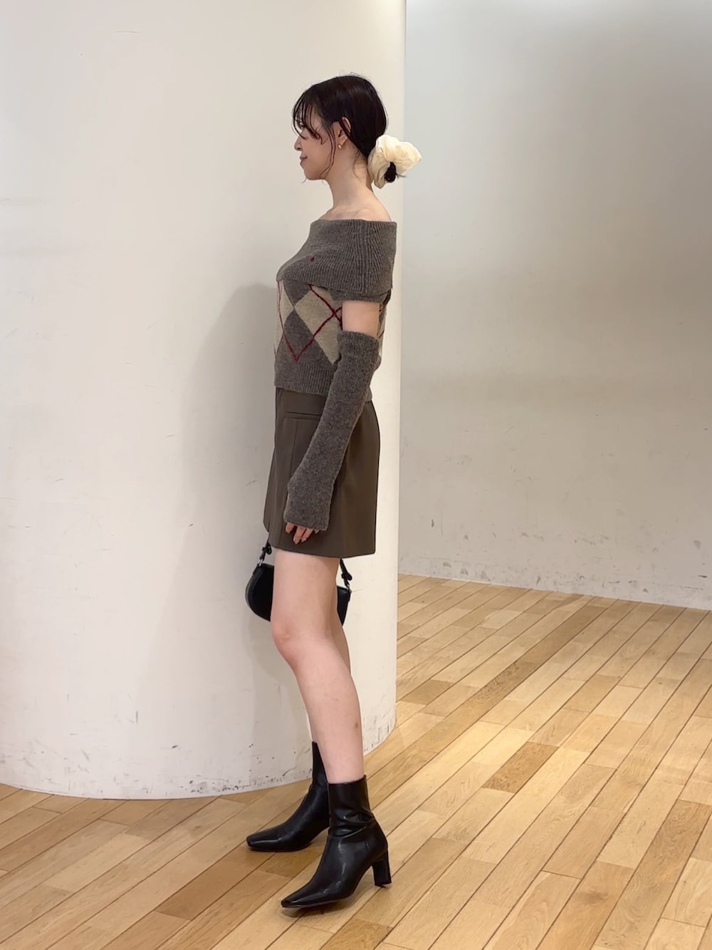 ブラウン系のその他パンツ、ブラウン系のニット/セーター、ブラック系のハンドバッグを着用したレディースの秋コーディネートの2枚目の写真