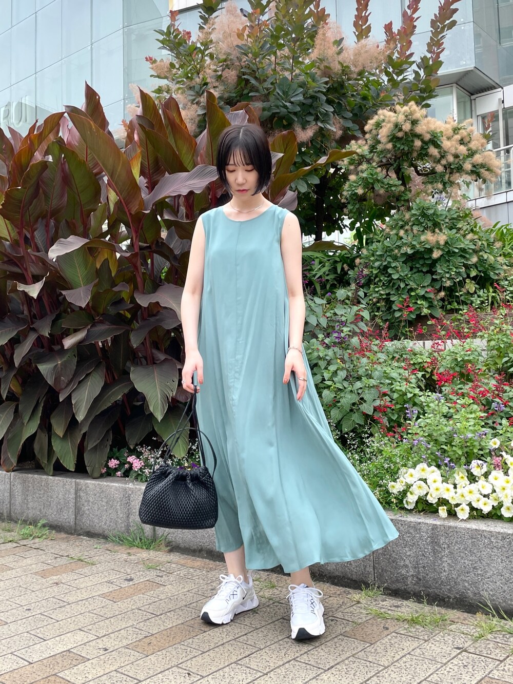 グリーン系のワンピース、ブラック系のハンドバッグを着用したレディースの夏コーディネートの2枚目の写真