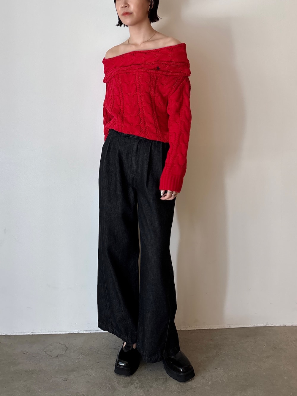 ブラック系のデニムパンツ、レッド系のニット/セーター、ブラック系のローファーを着用したレディースの秋コーディネートの2枚目の写真