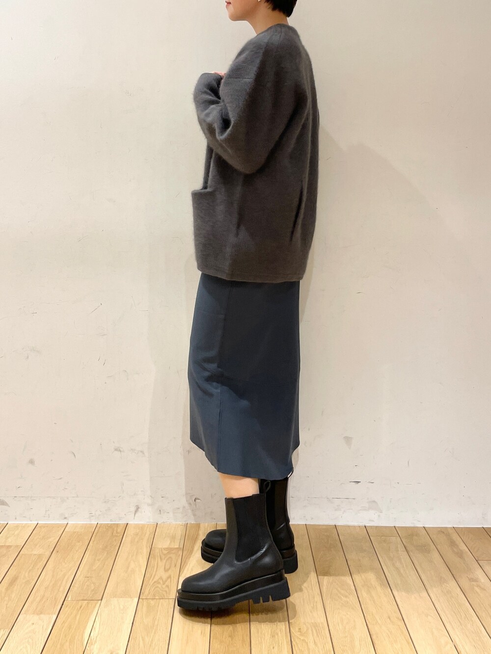 グレー系のカーディガン/ボレロ、グリーン系のニット/セーター、グリーン系のスカートを着用したレディースの冬コーディネートの6枚目の写真