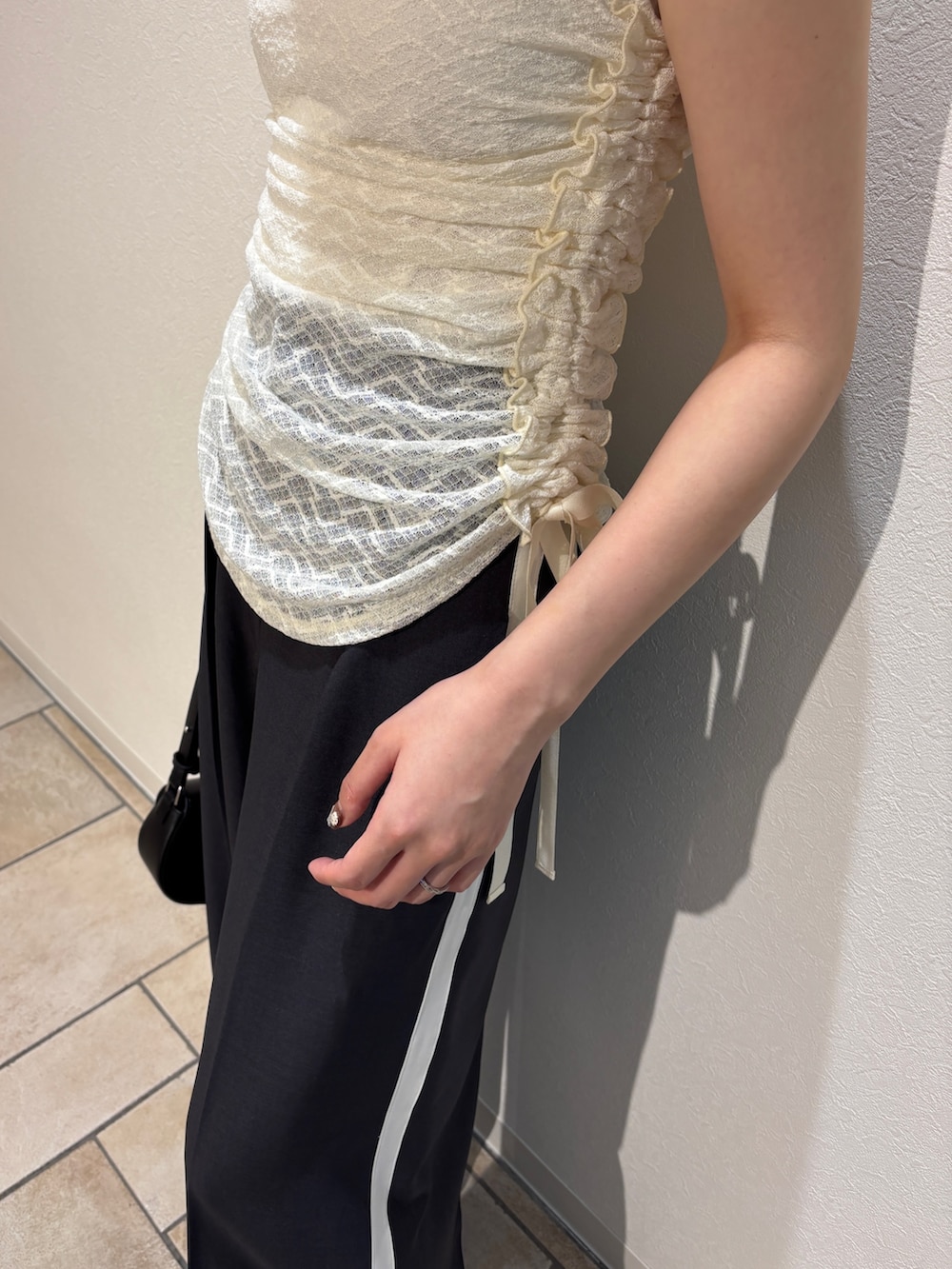 ホワイト系のシャツ/ブラウス、ブラック系のハンドバッグ、ホワイト系のサンダルを着用したレディースの夏コーディネートの6枚目の写真