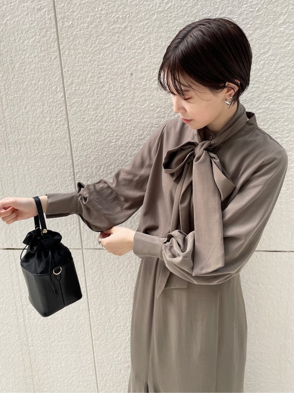 ブラック系のその他シューズ、ホワイト系のその他アウター、ブラウン系のシャツ/ブラウスを着用したレディースの冬コーディネートの6枚目の写真