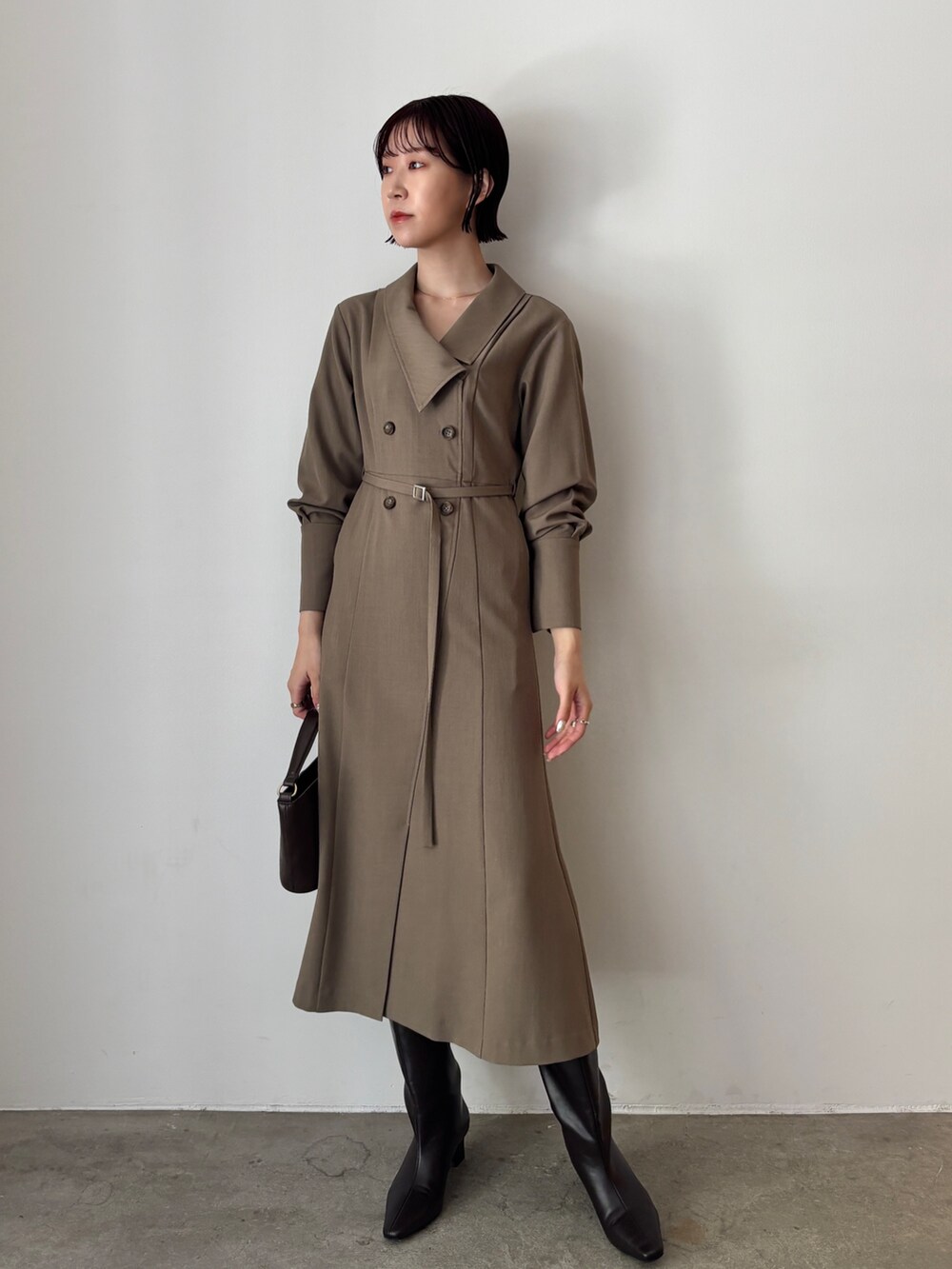 ホワイト系のワンピース、ブラウン系のブーツ、ブラウン系のハンドバッグを着用したレディースの秋コーディネートの5枚目の写真