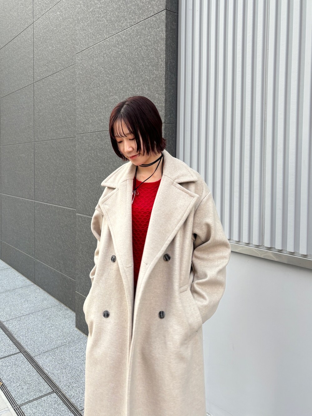 レッド系のワンピース、ホワイト系のチェスターコートを着用したレディースの冬コーディネートの6枚目の写真
