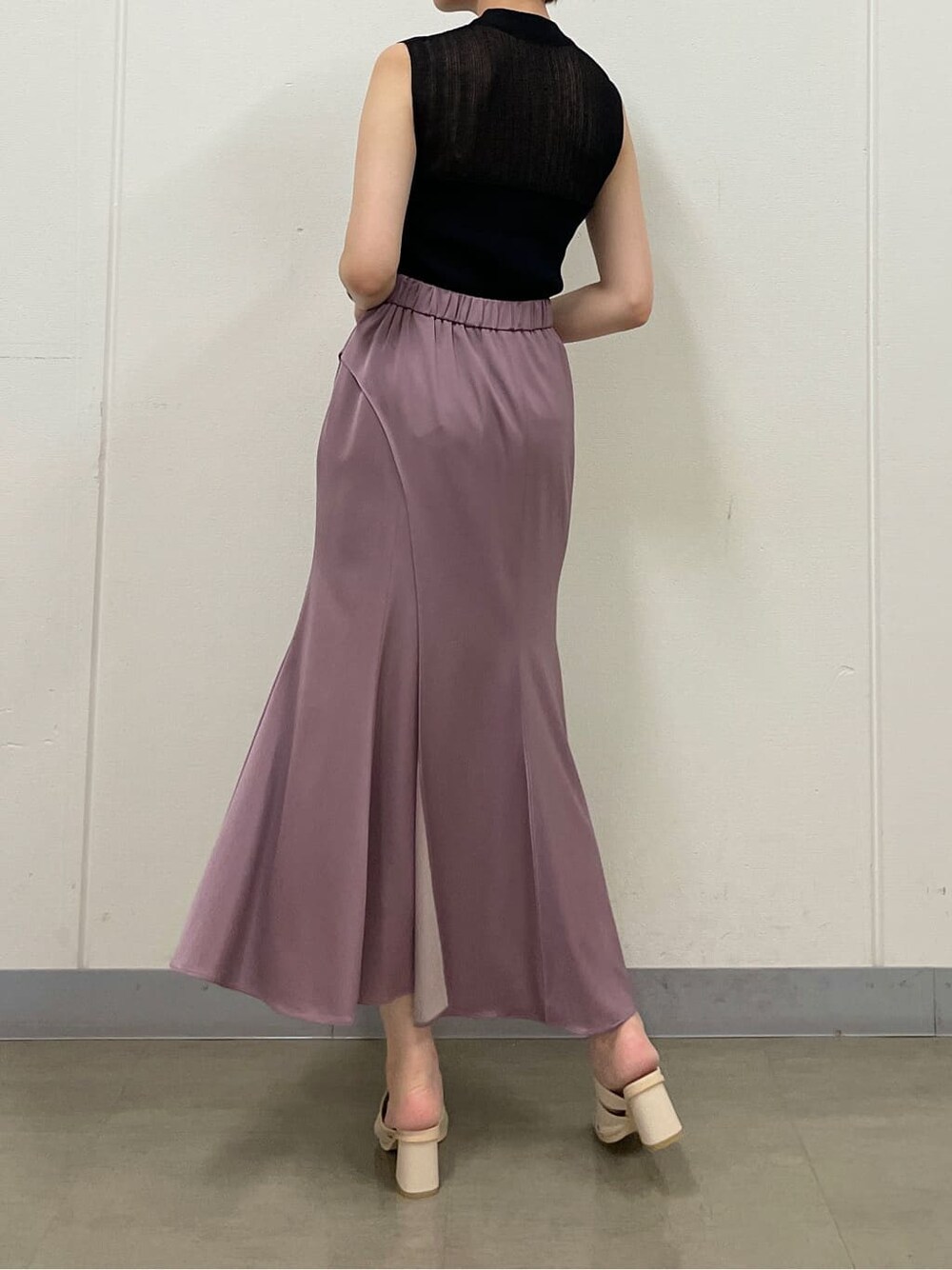 ピンク系のスカート、ホワイト系のサンダル、ブラック系のニット/セーターを着用したレディースの夏コーディネートの5枚目の写真