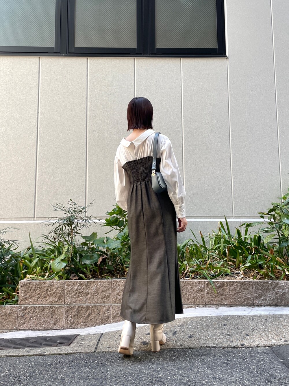 ブラウン系のワンピース、ブルー系のショルダーバッグ、ホワイト系のブーツを着用したレディースの秋コーディネートの5枚目の写真