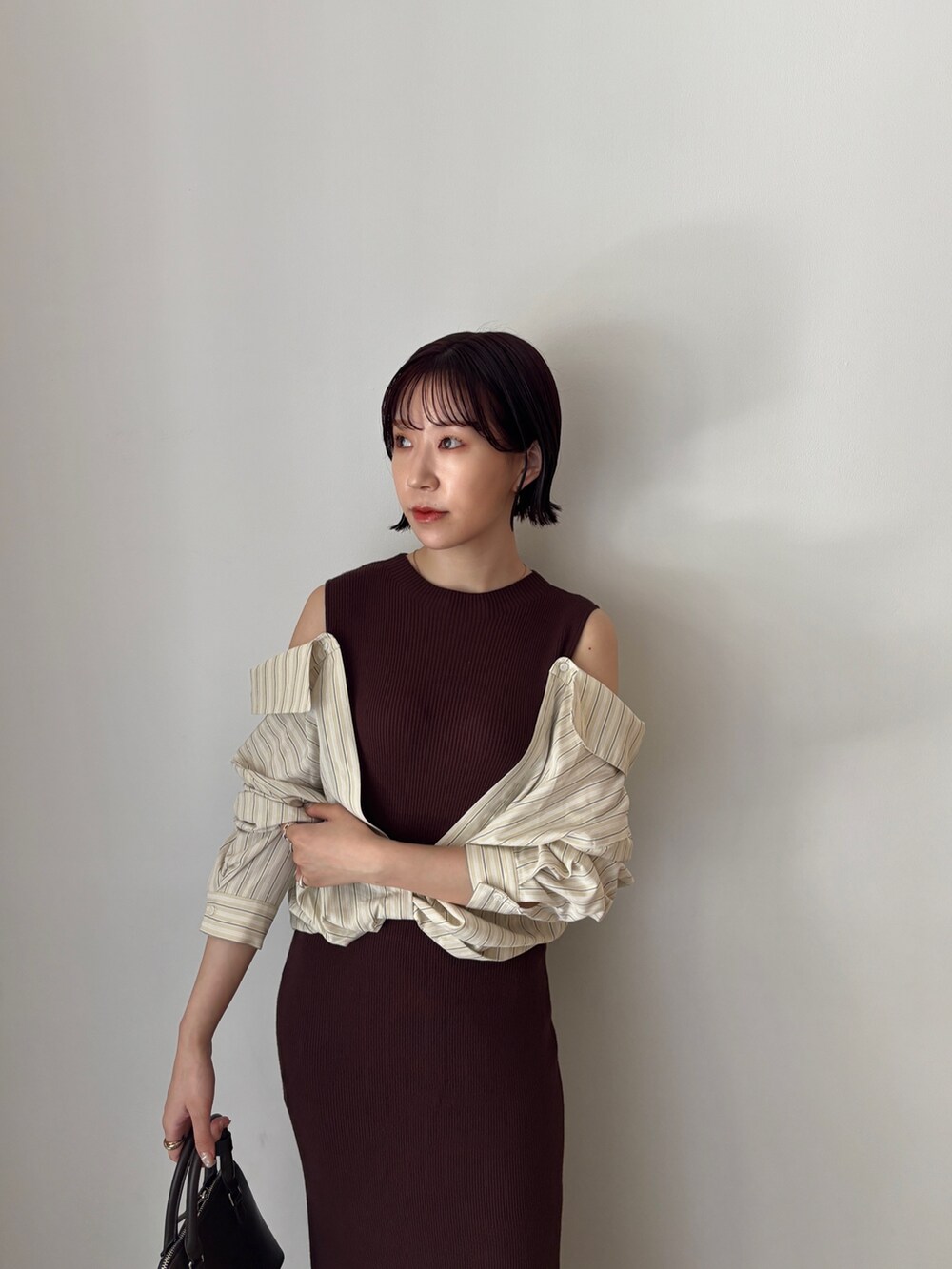 ブラウン系のワンピース、ブラウン系のボストンバッグ、ブラウン系のパンプスを着用したレディースの秋コーディネートの6枚目の写真