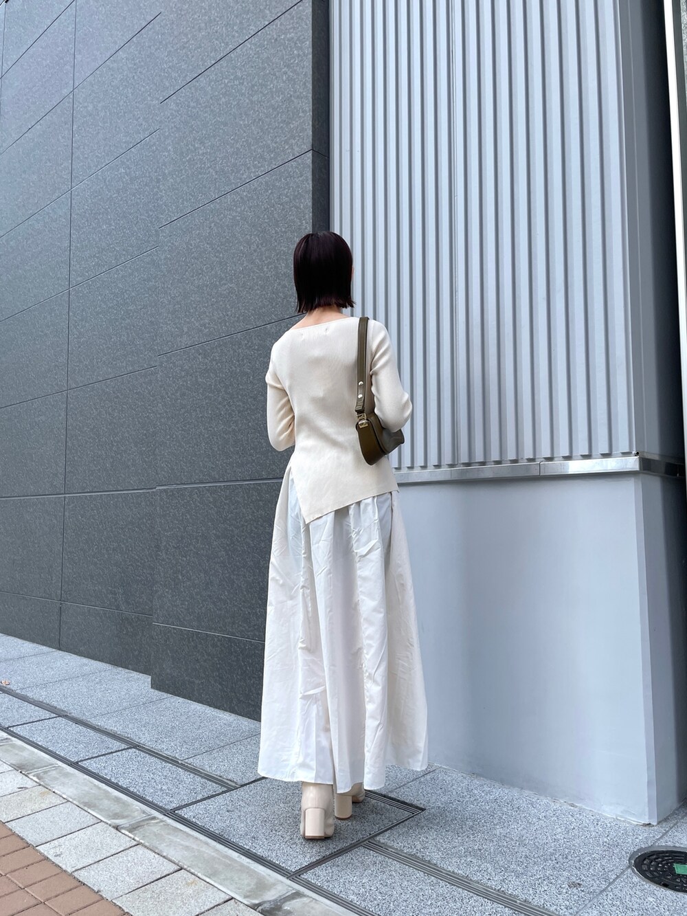 ブラウン系のショルダーバッグ、ホワイト系のブーツ、ホワイト系のワンピースを着用したレディースの春コーディネートの4枚目の写真