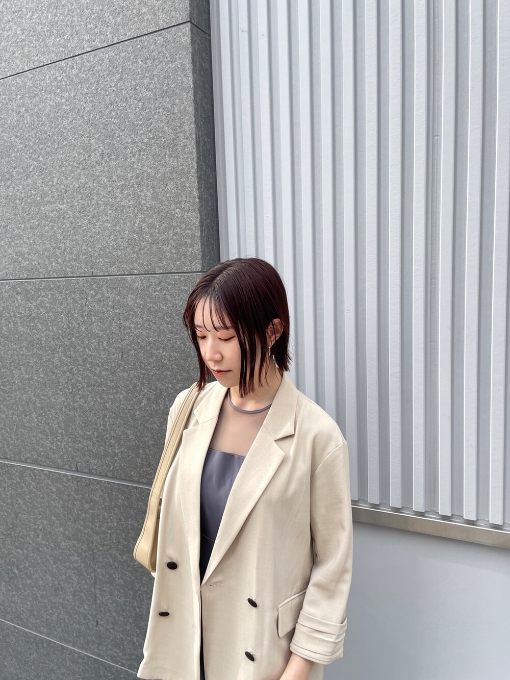 グレー系のパンツドレス、その他のパンプス、ベージュ系のテーラードジャケットを着用したレディースの春コーディネートの6枚目の写真