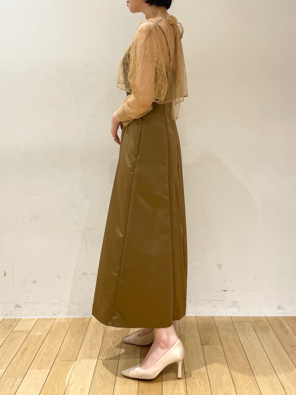 ブラウン系のドレス、ベージュ系のクラッチバッグ、ベージュ系のパンプスを着用したレディースの夏コーディネートの5枚目の写真