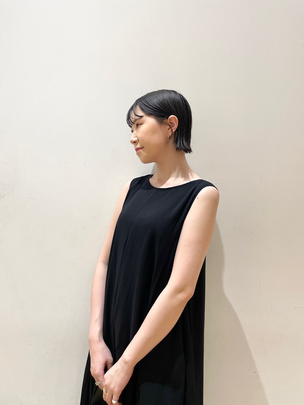 ブラック系のワンピース、ブラック系のハンドバッグ、ブラウン系のサンダルを着用したレディースの夏コーディネートの9枚目の写真