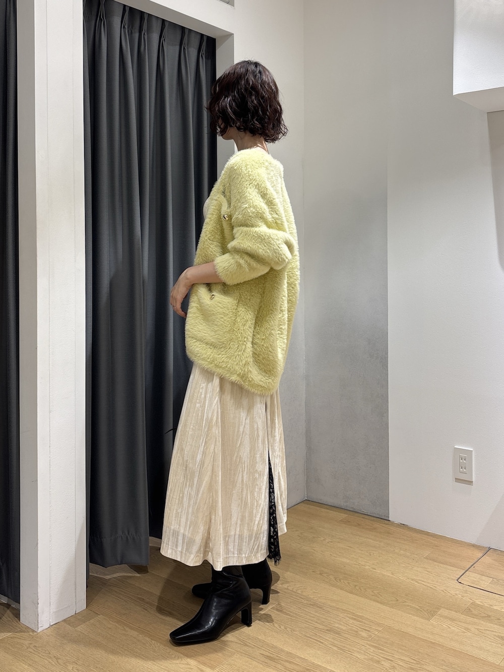 ホワイト系のワンピース、イエロー系のカーディガン/ボレロ、ブラウン系のハンドバッグを着用したレディースの秋コーディネートの3枚目の写真