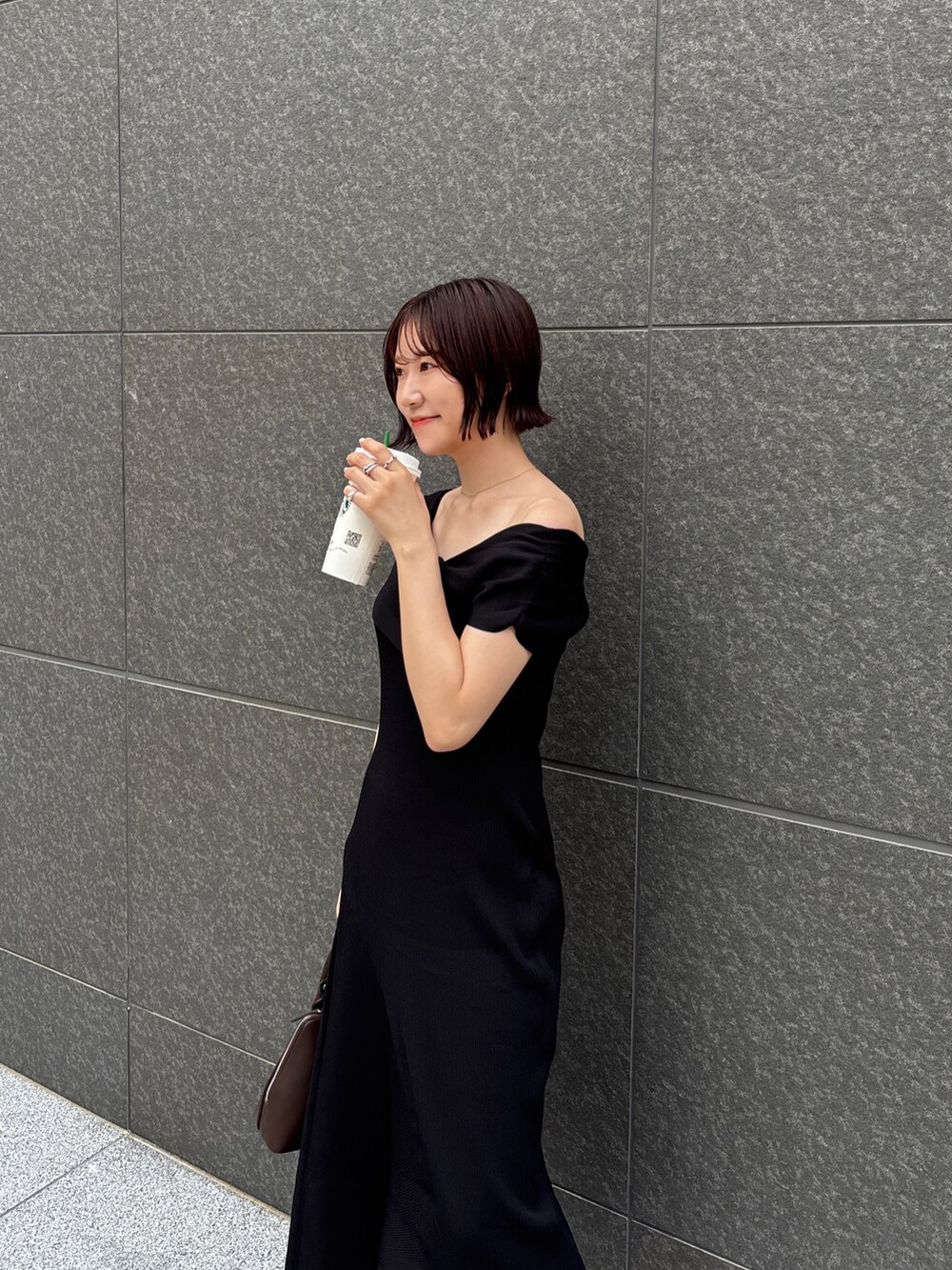 ブラウン系のパンプス、ブラウン系のボストンバッグ、ブラック系のワンピースを着用したレディースの夏コーディネートの5枚目の写真