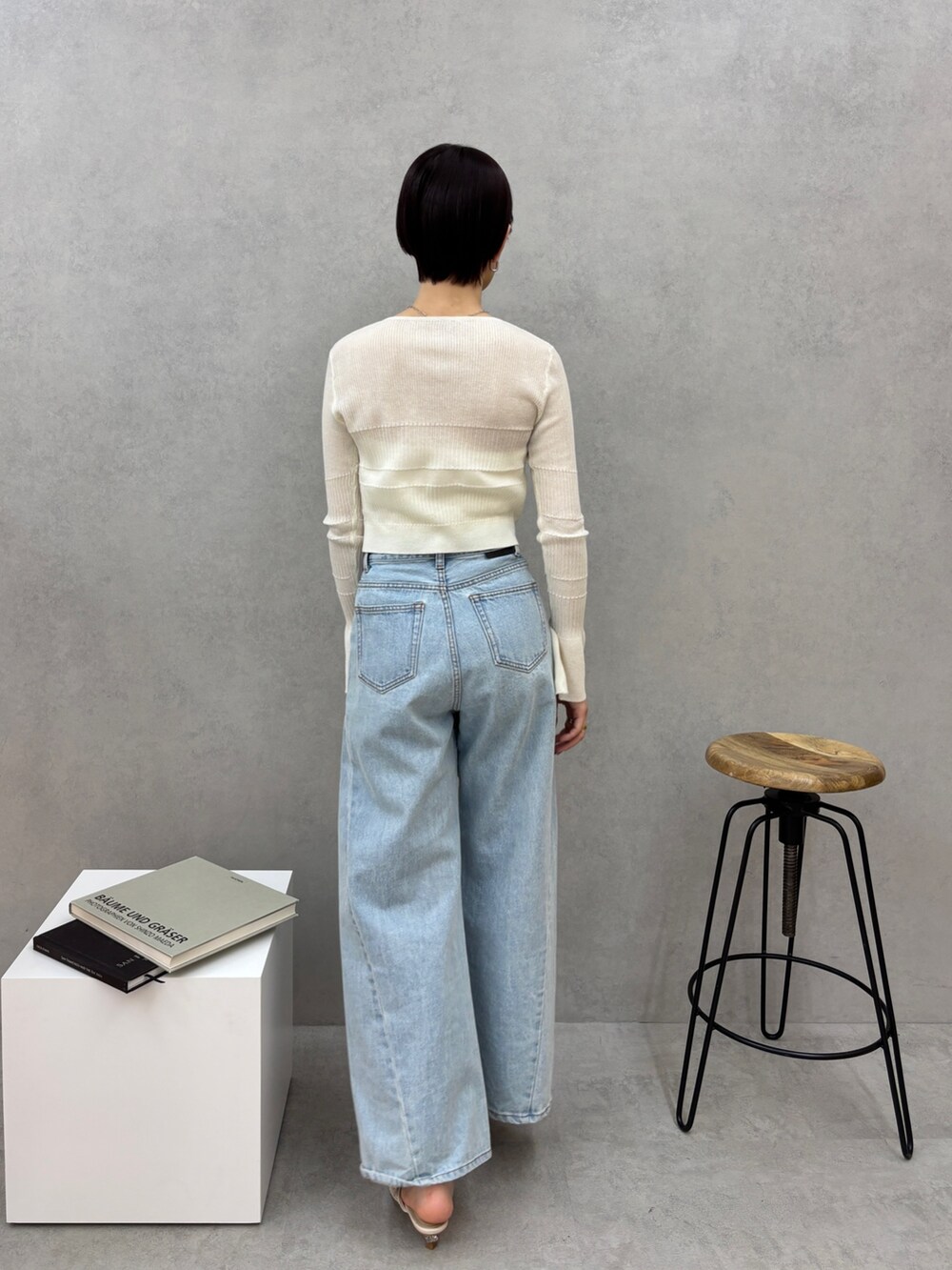 ブルー系のデニムパンツ、ホワイト系のカーディガン/ボレロ、ホワイト系のサンダルを着用したレディースの春コーディネートの4枚目の写真