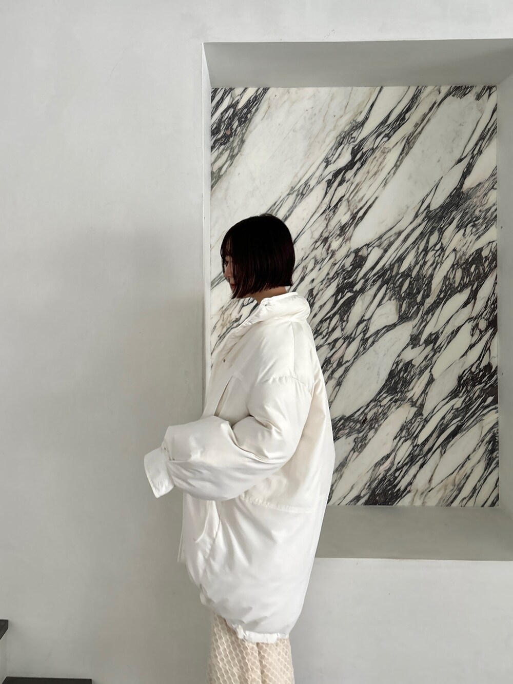 ホワイト系のワンピース、シルバー系のブーツ、ホワイト系のダウンジャケット/コートを着用したレディースの秋コーディネートの8枚目の写真