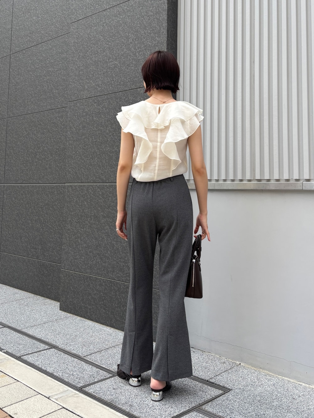 グレー系のその他パンツ、ホワイト系のシャツ/ブラウス、ブラウン系のボストンバッグを着用したレディースの夏コーディネートの3枚目の写真