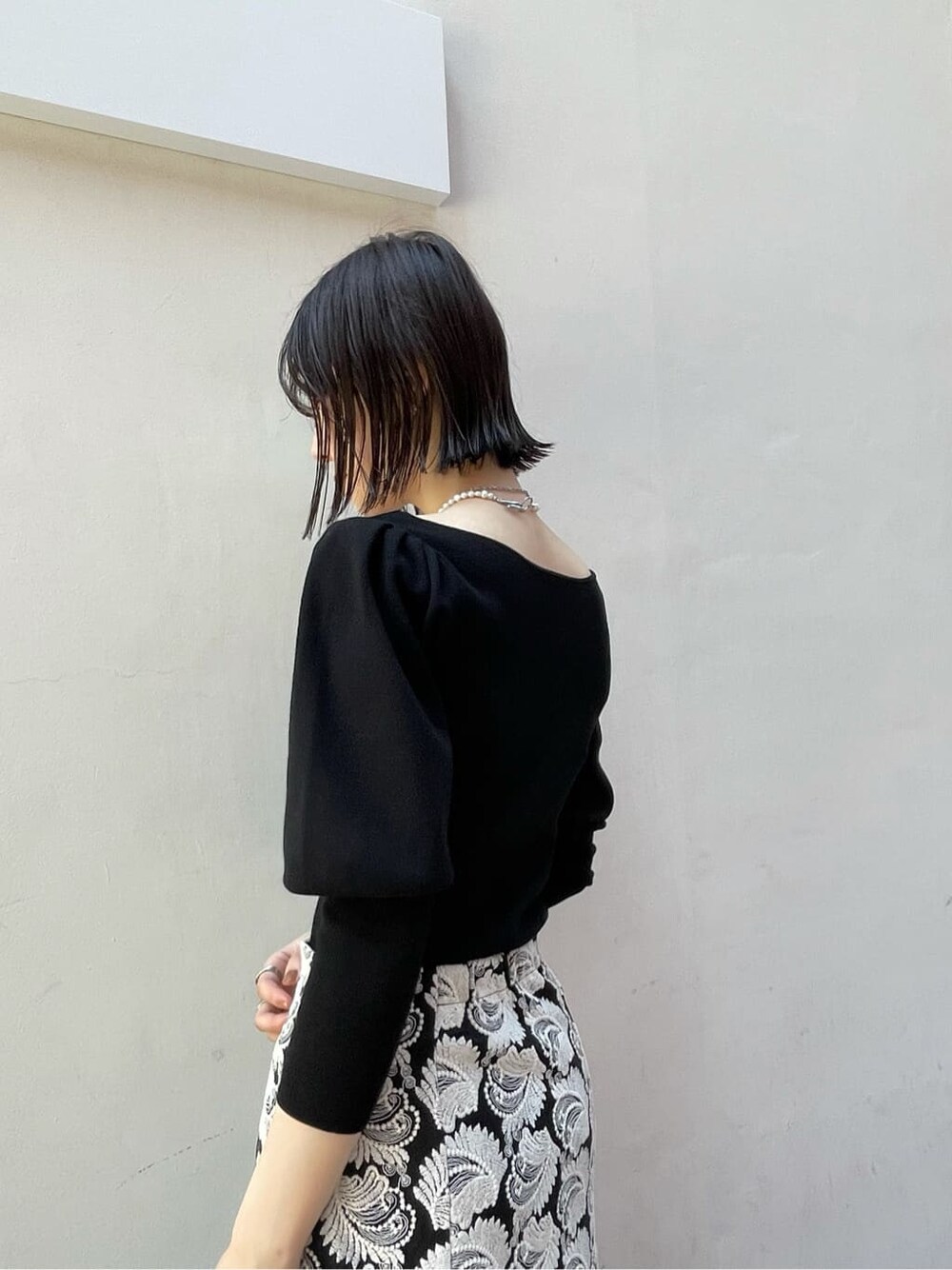 ブラック系のスカート、ブラウン系のショルダーバッグ、ホワイト系のその他シューズを着用したレディースの秋コーディネートの6枚目の写真