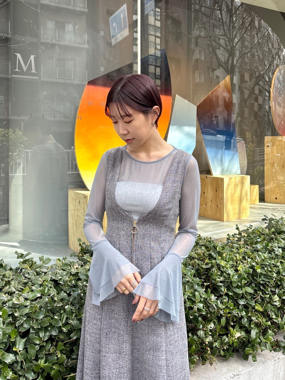グレー系のジャンパースカート、ブルー系のTシャツ/カットソー、ブラック系のサンダルを着用したレディースの春コーディネートの7枚目の写真