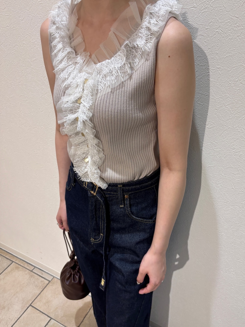 ベージュ系のニット/セーター、ブルー系のデニムパンツ、ブラウン系のサンダルを着用したレディースの夏コーディネートの7枚目の写真