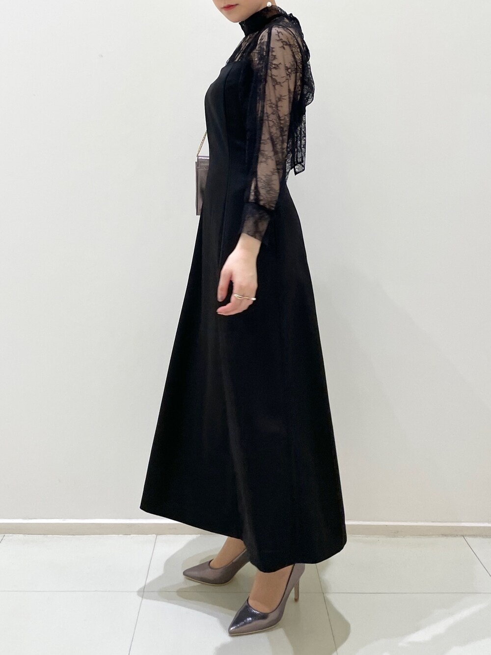 ブラック系のドレス、シルバー系のパンプス、シルバー系のハンドバッグを着用したレディースの春コーディネートの9枚目の写真