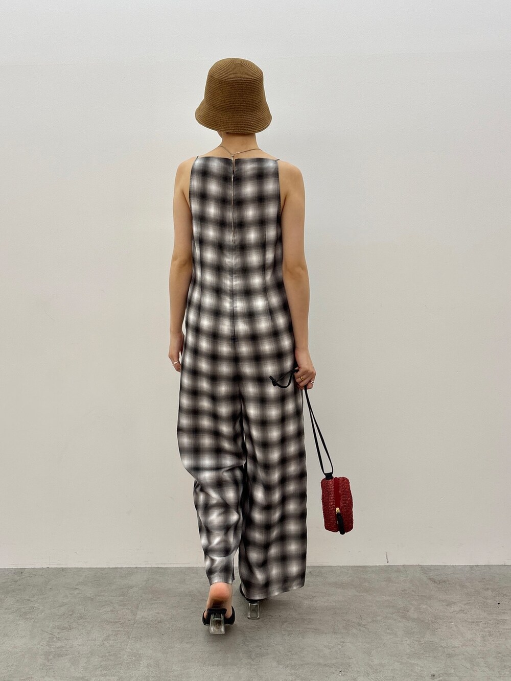 ブラック系のつなぎ/オールインワン、レッド系のショルダーバッグ、ブラック系のサンダルを着用したレディースの春コーディネートの4枚目の写真